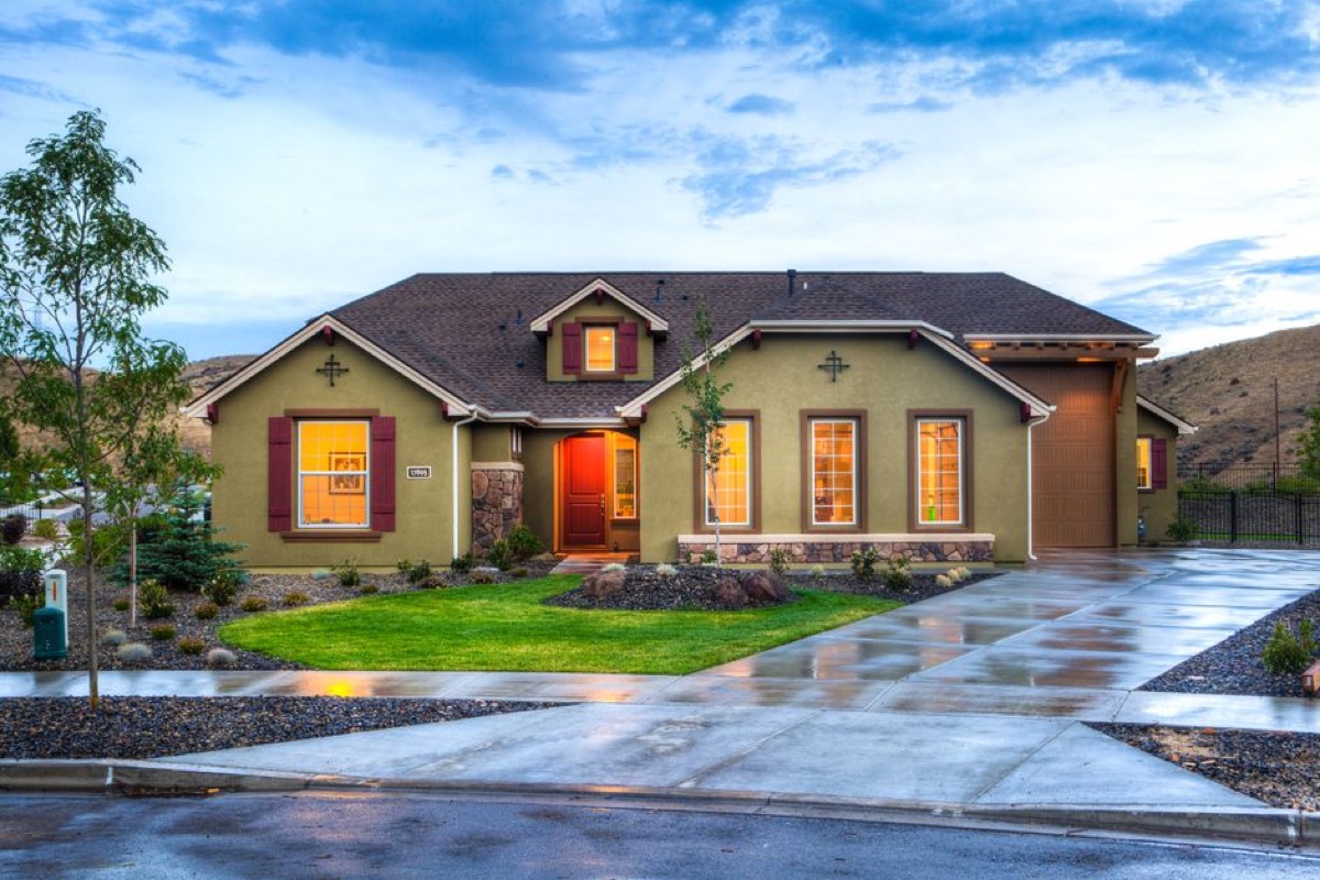 Well-lit suburban home exterior at dusk illustrating the value of backup power keeping lights on during outages