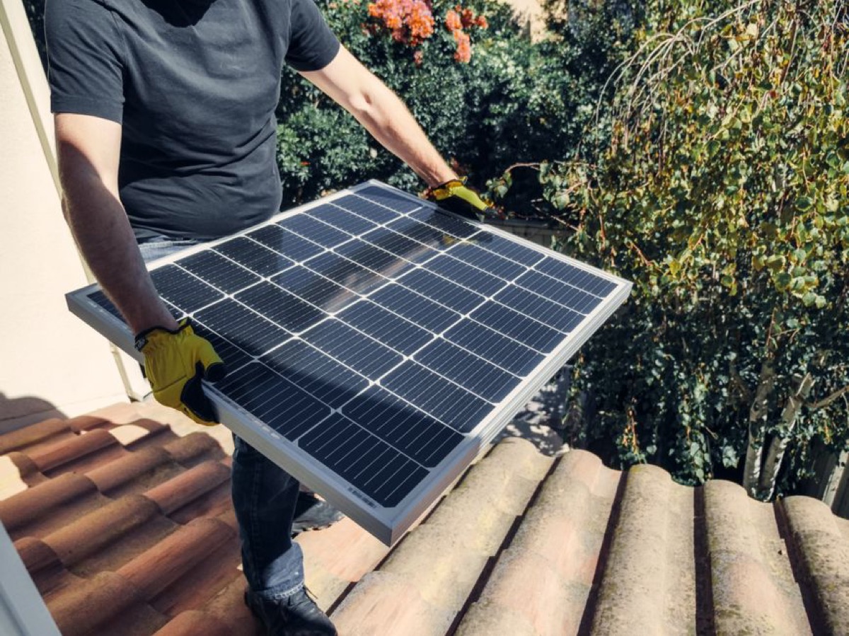 Technician performing standby generator installation work with professional tools and electrical connections