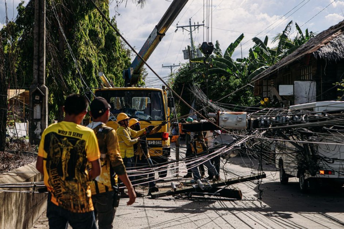 Utility workers repairing storm-damaged power lines requiring emergency backup generator power